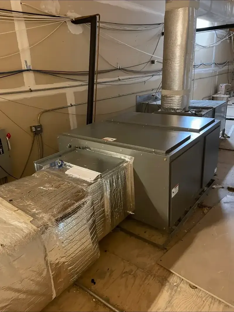 Commercial HVAC unit and ductwork installed in a mechanical room